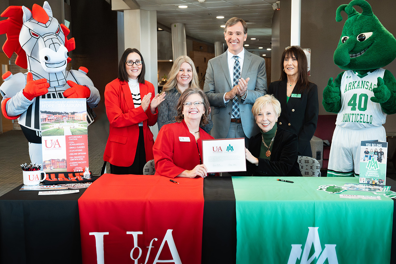 Front row left to right: Laura Clark, UAHT interim chancellor and Dr. Peggy Doss, UAM Chancellor.  Back row: Spike the Iron Horse; Dr. Mikki Curtis, UAHT dean of arts, humanities, and education; Jennifer Teresa, UAHT dean of business and technical education; Chris Thomason, UA System VP for strategic and community college partnerships; Dr. Kim Level, UAM dean of education; and Weezie the Weevil.